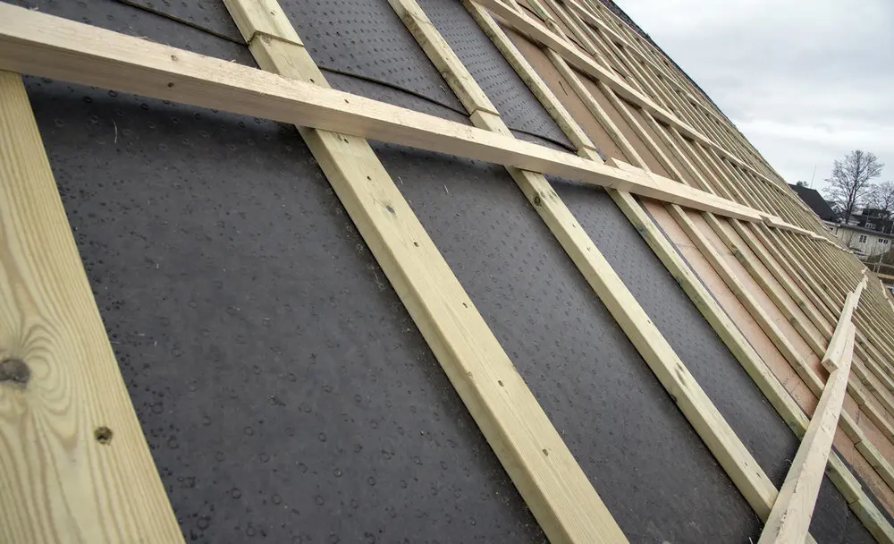 Nærbilde av taklekter som er lagt oppå takpapp.