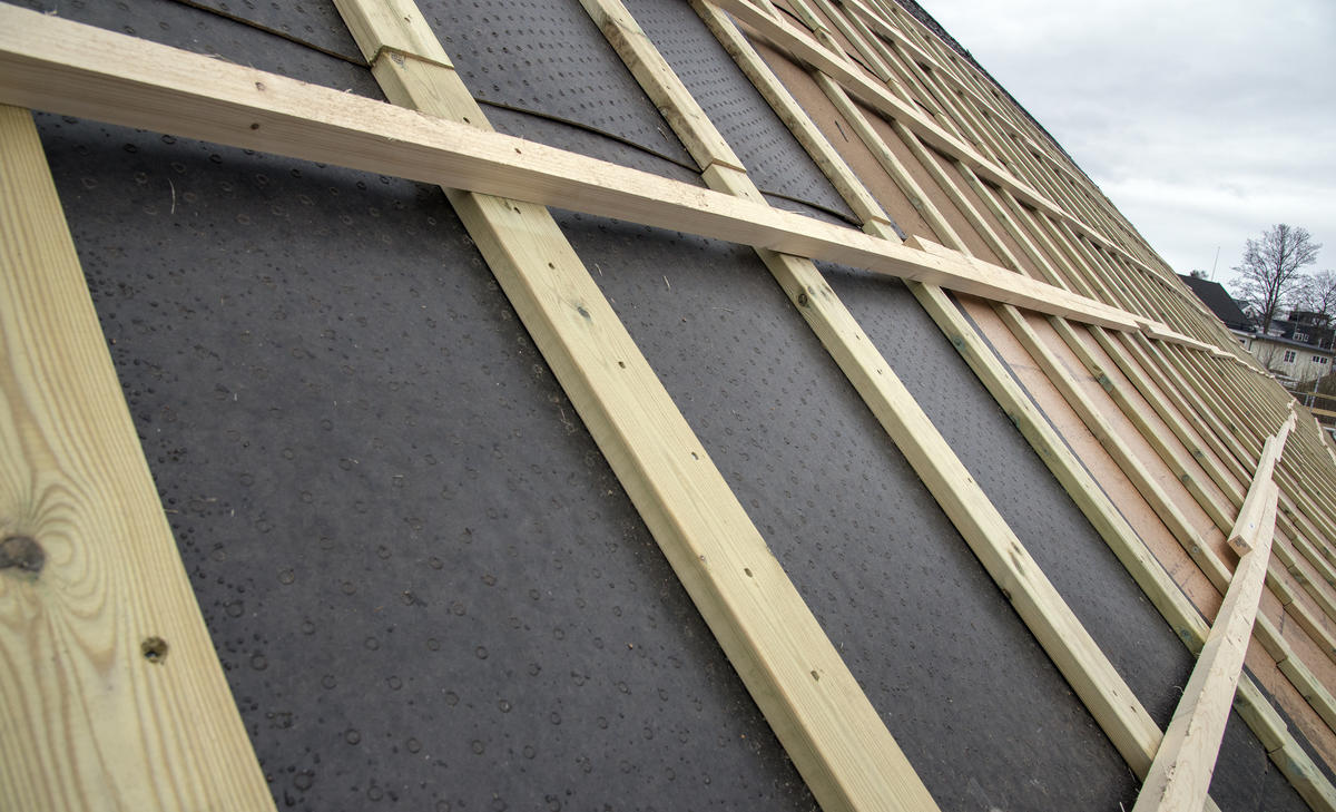 Nærbilde av taklekter som er lagt oppå takpapp.