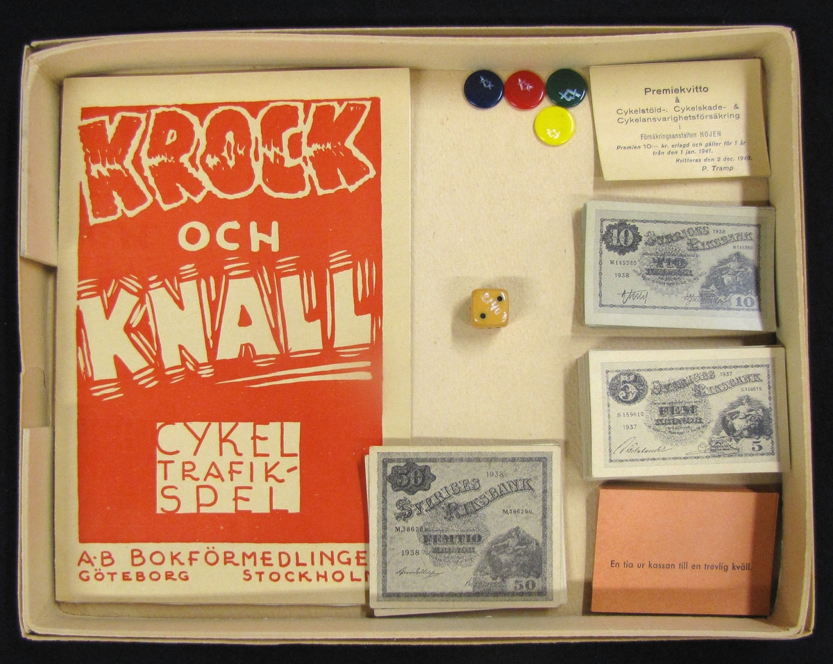 Spel kallat '' Cykeltrafikspelet Krock och Knall .'' Spelet ligger i en kartong med måtten : L. 31 cm. B. 24 cm.  H. 3 cm, och innehåller 81 delar. Bland dessa delar ingår, spelregelhäfte, Sverigekarta, leksakssedlar, kort med spelorder, spelpoletter och tärning. På kartongens framsida visas cyklister som krockar samt en polisman som ger tecken. Bild och text är tryckt i svart, rött och vitt. 

Spelet kostade 3,50 kr i inköp. Samlinga delar märkta VM 21 407.