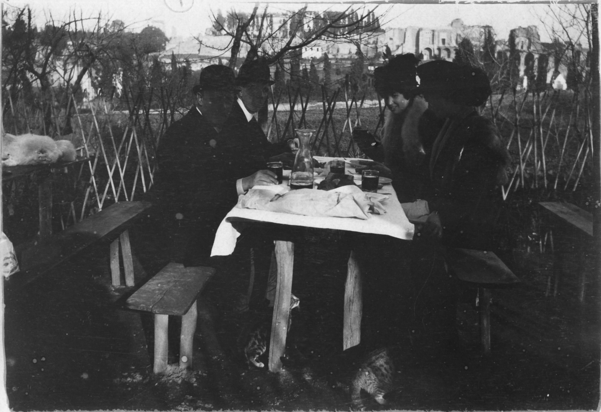 John och Ester Bauer tillsammans med vänner vid ett matbord utanför Rom i Italien, julen 1908.