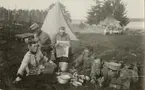Fältlunch med soldater från Livgardet till häst K 1. I bakgrunden syns tält och vagn.