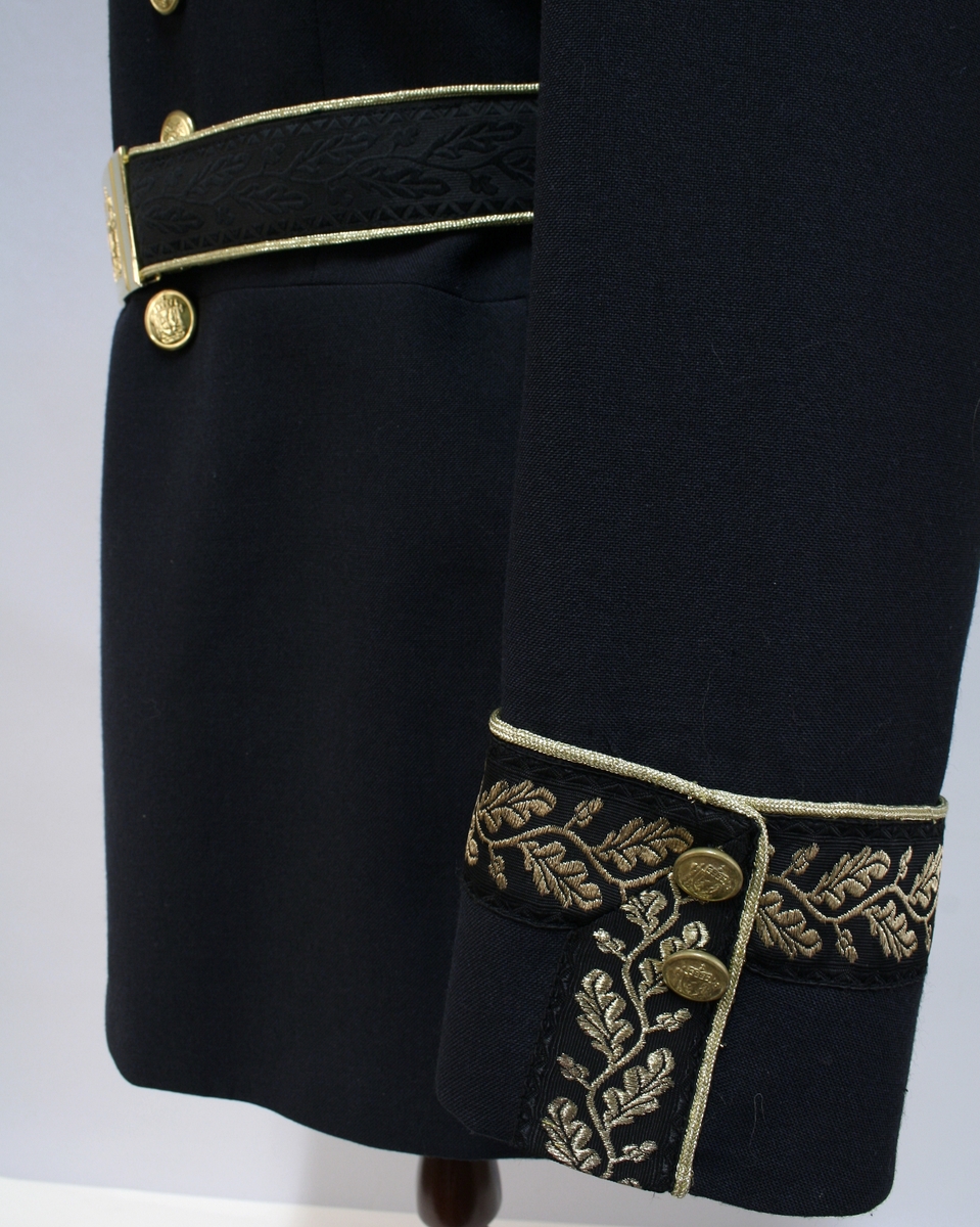 Sort gallauniform med gullbrodert ekebladsdekor på krave og mansjetter og skuldersitinksjon for politimester. Jakke og bukse med belte.