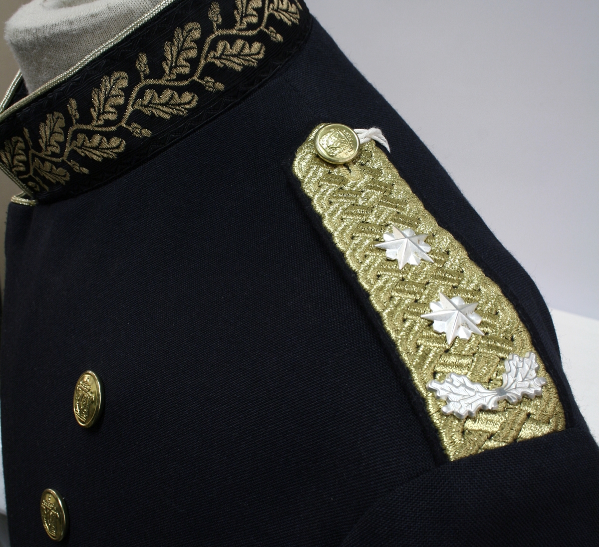 Sort gallauniform med gullbrodert ekebladsdekor på krave og mansjetter og skuldersitinksjon for politimester. Jakke og bukse med belte.