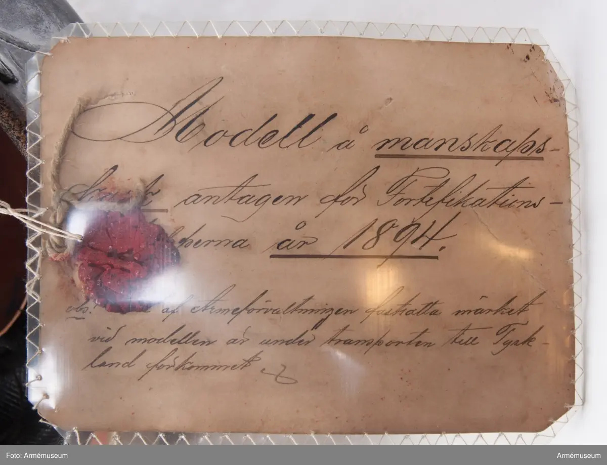 Vidhängande modelletikett: "Modell å manskapskask antagen för Fortifikations- (oläsligt)-perna år 1894. obs! (oläsligt) af Arméförvaltningen fastsatta märket vid modellen är under transporten till Tyskland förkommet".