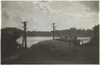 Vy från Beckholmen 1920-tal. T v fartyg i docka samt i bakgrunden berget Fåfängan på andra sidan Saltsjön. I förgrunden telefonstolpar, staket och t h gaveln av mindre träbyggnad.