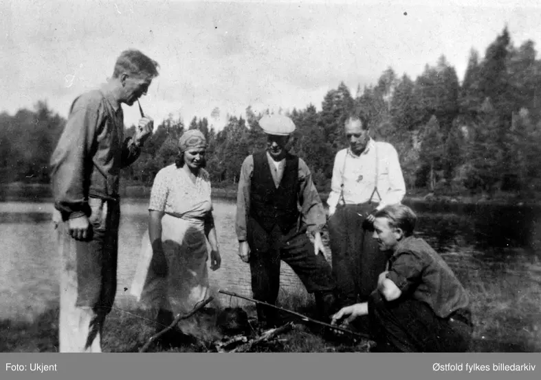 På tyttebærplukking i Rømskog 1947. Rast med koking av kaffi over bålet. 
Erling, Gudrun, Ole, Anton og Arne Bergli.
Arne Bergli er på bildet og sitter på huk. Ole er far til Erling og Arne. Anton er far til Gudrun. Gudrun og Arne er min mormor og morfar til informant.