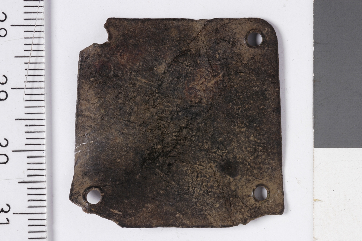 MALV: SE BESK., TILNÆRMET KVADRATISKE PLATER MED AVRUNDEDE HJØRNEROG ET NAGLEHULL I HVERT HJØRNE. A: L. 33 MM, B. 33 MM.  B: L. 25 MM, B. 23 MM, HAR NAGLER AV JERN SITTENDE PÅ PLASS.