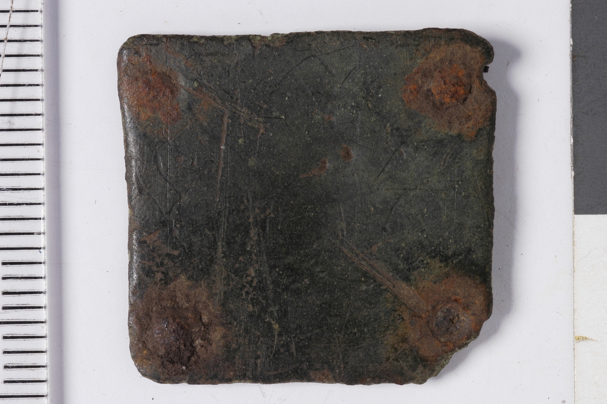 MALV: SE BESK., TILNÆRMET KVADRATISKE PLATER MED AVRUNDEDE HJØRNEROG ET NAGLEHULL I HVERT HJØRNE. A: L. 33 MM, B. 33 MM.  B: L. 25 MM, B. 23 MM, HAR NAGLER AV JERN SITTENDE PÅ PLASS.