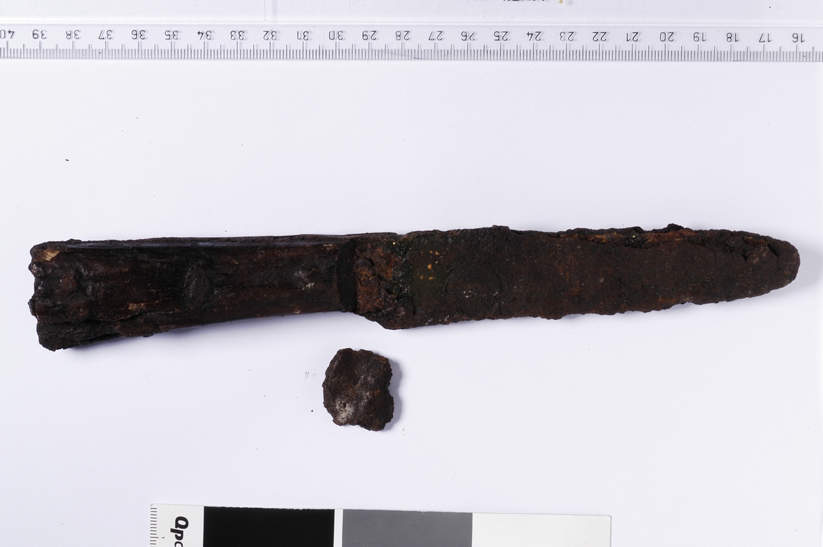 Kniv av jern med beinskaft som er naglet fast.