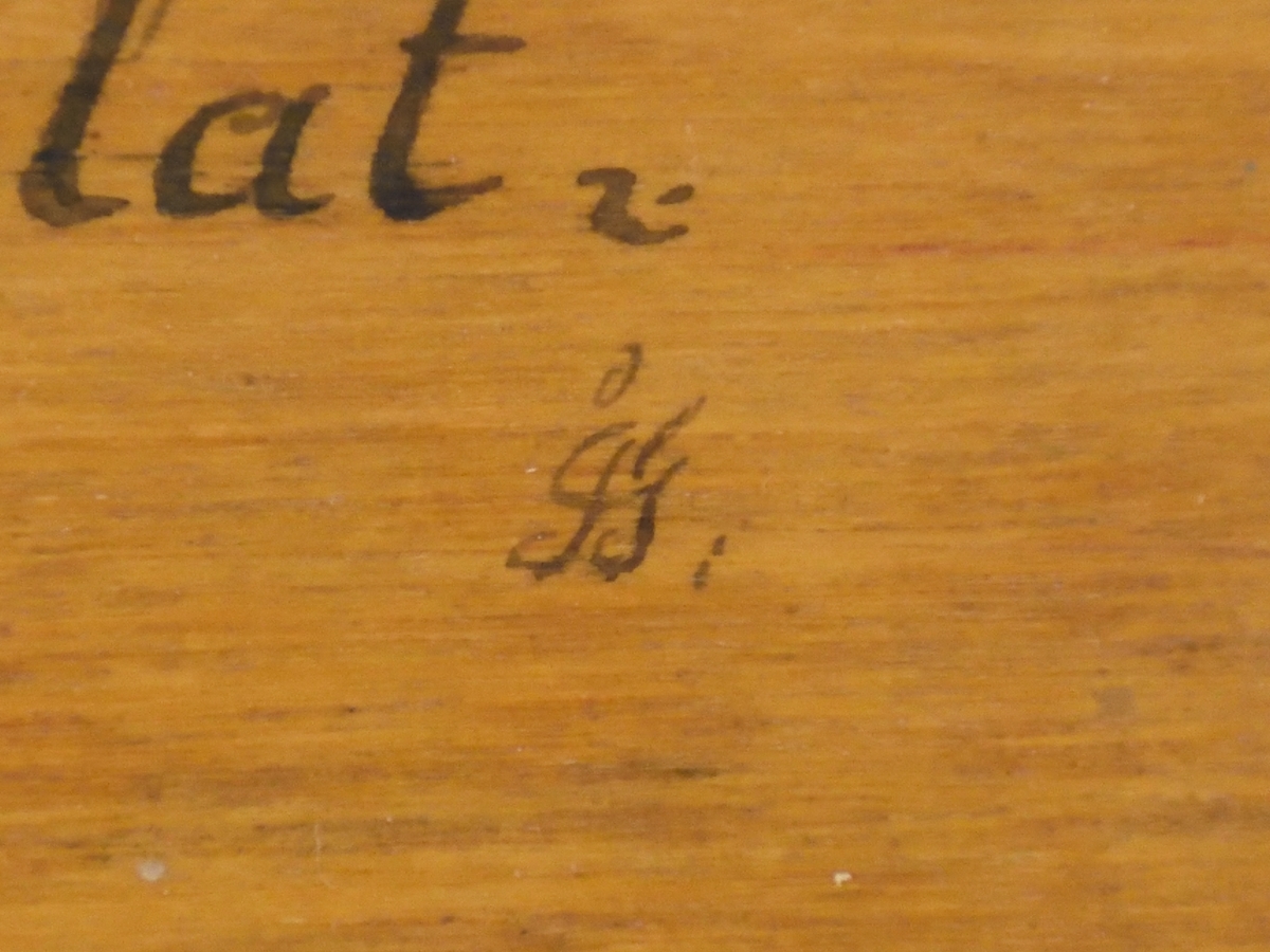 Skäktkniv av trä. På ena sidan av bladet finns blomsterornering i rött, vitt och grönt samt med bläck skrivna verser. Den andra sidan är omålad. På handtagets nederdel finns en snidad knut.