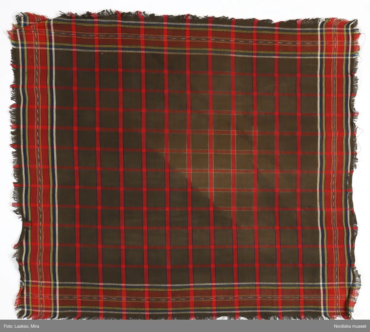 Huvudliggaren:
"Sorgdräkt för kvinna. Särk med 'hängseltåg', 'särkyvdel'; vit -'häsklä'; blått livstycke; svart tröja; huvudduk; 'svart näsduk'; hatt; 'raskförklä', 'sockar',  'hårbandsvifsa', huvudbindel."

Bilaga:
a: "8 Särk, övdel. av linne eller blågarn. med broderade linningar på överdelen"
c: "11. Hvit häsklä."
Anm: Kung Kerstin Larsdotters resa i Floda sn Dalarna 24/2 - 8/3 1912. Innehåller förteckning på inköp av dräktdelar från Floda, inv nr 117 216 - 117 239. Här finns  tillverkningstid och beskrivningar på vissa av dräktdelarna.  I vissa fall nämns också utförligt på vilka helgdagar dräktdelen  användes.

Katalogkort:
a: Hängselsärk
b. Överdel av halvlinne vävt i kypert.
c.  Halskäde av småmönstrat bomullstyg, liknande kambris, vävt  i kypertvariation med drällmönster.
d. Livstycke av mörkblå kraftig vadmal,
e. Tröja av grov svart vadmal

i. 
 Mönstervävt band med upplockat mönster i rött z-tvinnat ullgarn på vit linnebotten, med hjärtan, kryss och rombformer, 2 band om vardera 124 cm har vikts och sytts ihop så att det ena bildar en ögla och det andra har fria ändar avslutade med en tofs i bandets garn.
Läs mer om dräktskicket i Floda i: Albert Alm, Dräktalmanacka för Floda socken, Nordiska museet, Sthlm 1930
/Berit Eldvik 2005-04-14