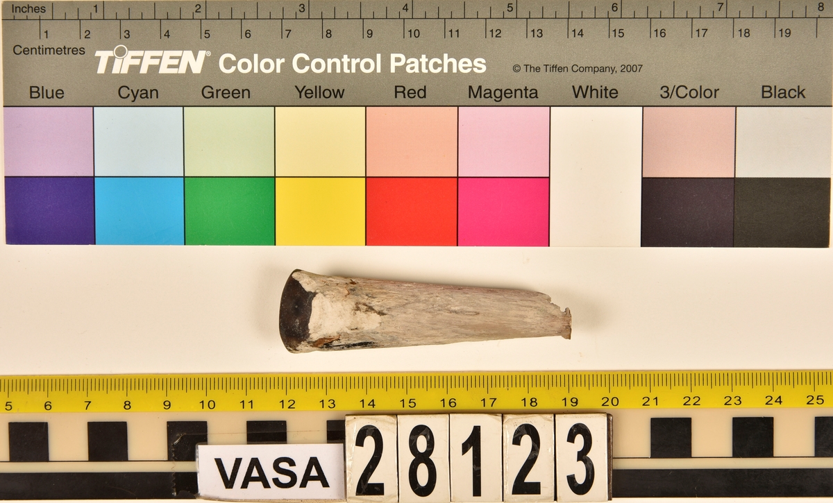 Fragment av horn. Avbruten i ena änden och sågad diagonalt till en spets i den andra änden. Ena sågytan har slipad sida. Hornets ursprungliga yta är bortnött och ytan känns närmast som torkat trä.
