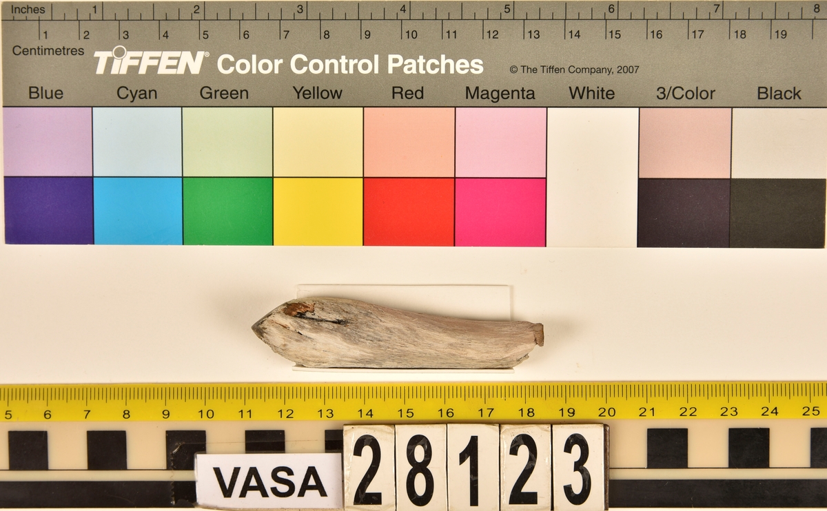 Fragment av horn. Avbruten i ena änden och sågad diagonalt till en spets i den andra änden. Ena sågytan har slipad sida. Hornets ursprungliga yta är bortnött och ytan känns närmast som torkat trä.