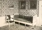 Interiörsbild av en huvudbyggnad i Strömsrum, bottenvåningen. Gustaviansk länstol med ursprunglig skinnklädsel.