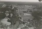 Flygfoto över Fliseryd, samhället med bostadshus och åkrar samt grusvägen.