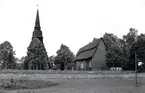 Vy över Frödinge kyrka med klockstapeln och stenmuren framför kyrkan.