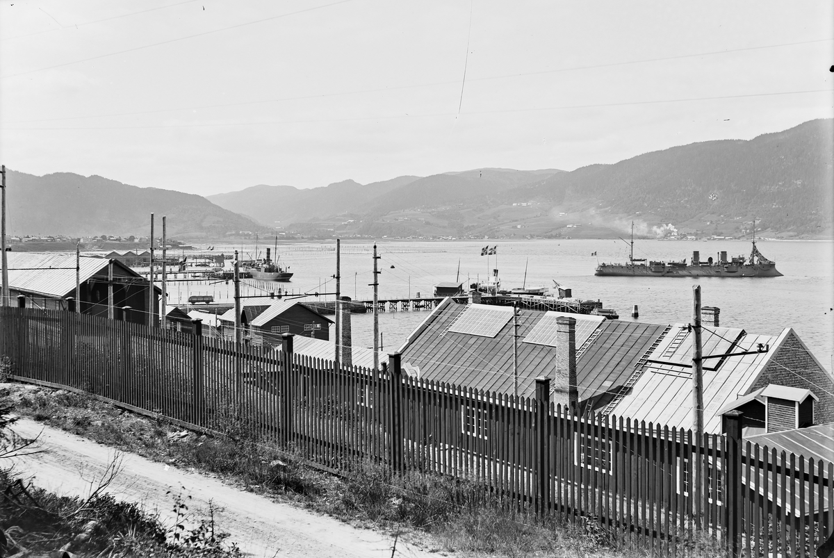 Thamshavn. Stakittgjerde i forgrunnen. Krysseren "Lavoisier" på fjorden.