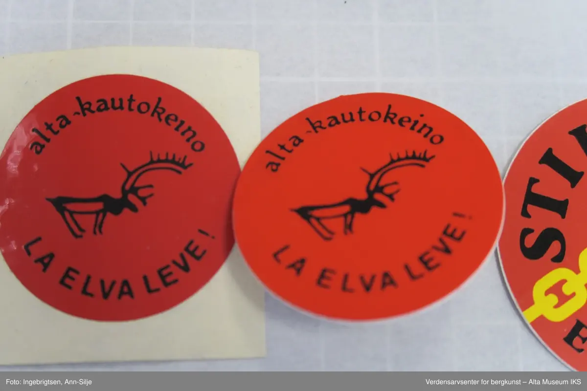 Runde merker, 19 stk.: La elva leve. Elva skal leve. Stilla. Hengemerke: 1 stk. Nålmerker: 3 stk.  Klistremerker: 6 stk. Tøymerker: 2 stk