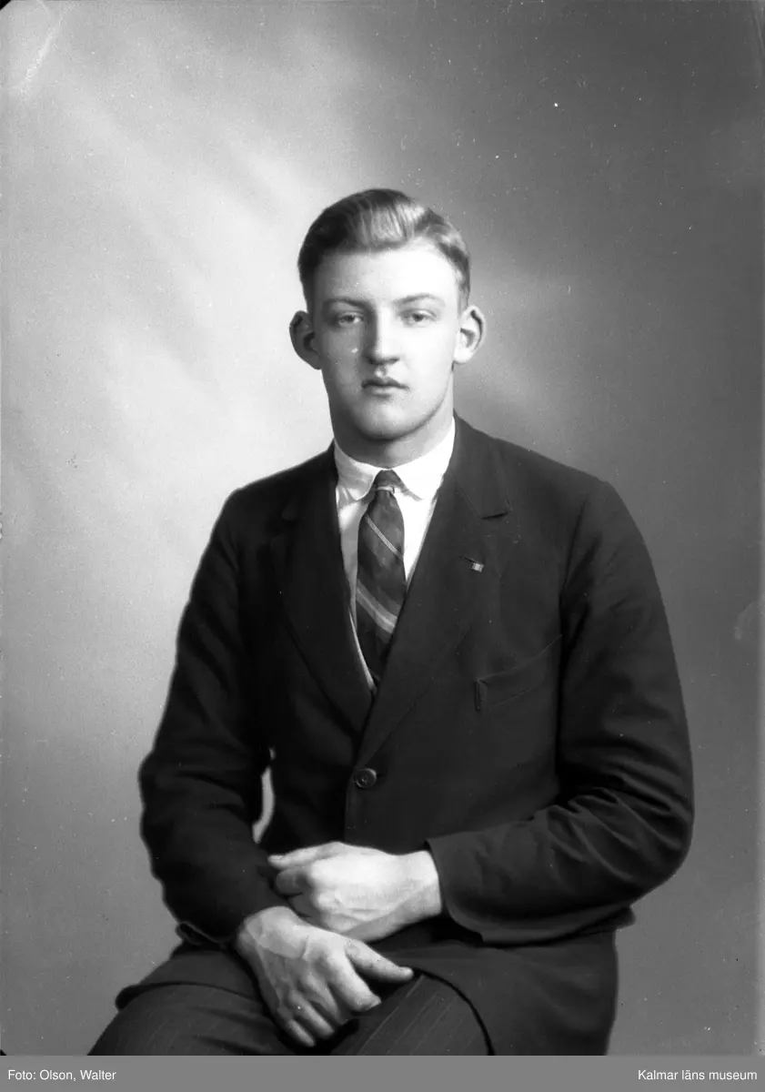 Bilden visar en ung man i mörk kavaj med väst. Enligt Walter Olsons journal är bilden beställd av Svea Löfberg, Grönskåra. [Möjligen är namnet en felskrift för Sven Löfberg; i så fall är det antagligen beställaren som bilden visar.]