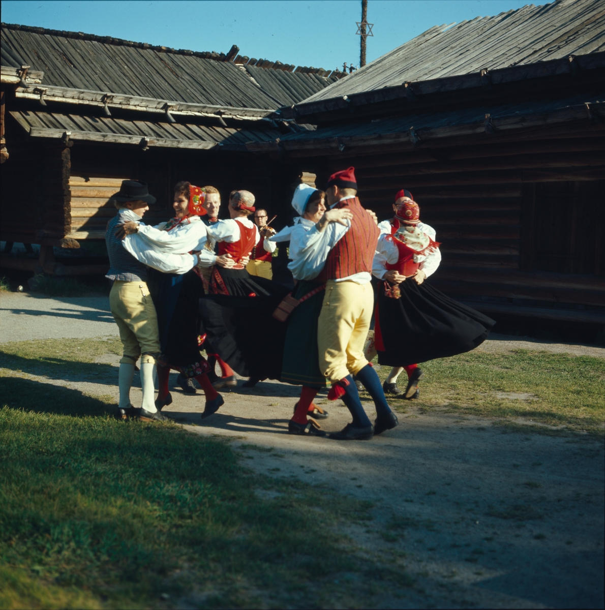 Ett folkdanslag dansar på Moragårdens gårdsplan.