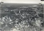 Flygfoto över Kristdala. Samhället med hus, kyrka och grusväg.