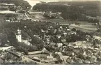 Överblick på samhället med kyrkan och grusvägen och bostadshus.