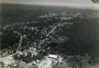 Flygfoto över Svalliden med bygatan bostadshus och träindustri.