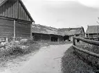 Bilden visar en ladugård i skiftesverk, och med  bundet halmtak.