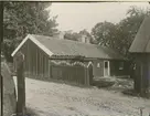 Gammal gård vid gatan mot Runsbäck. Stugan är en lång, låg envåningslänga, sammanbyggd med diverse bodar.