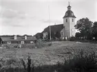 Musterhults kyrka med flaggstång och ryggåsstuga.