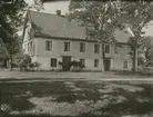 Ett bostadshus i sadeltak och putsad fasad i Löttorp.