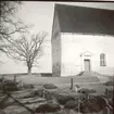 Kläckeberga kyrka. . Parti av kyrkogården med del av kyrkan i bakgrunden.