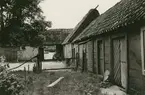 Portskjulet till höger. Till vänster Herbert Karlssons ladugård.