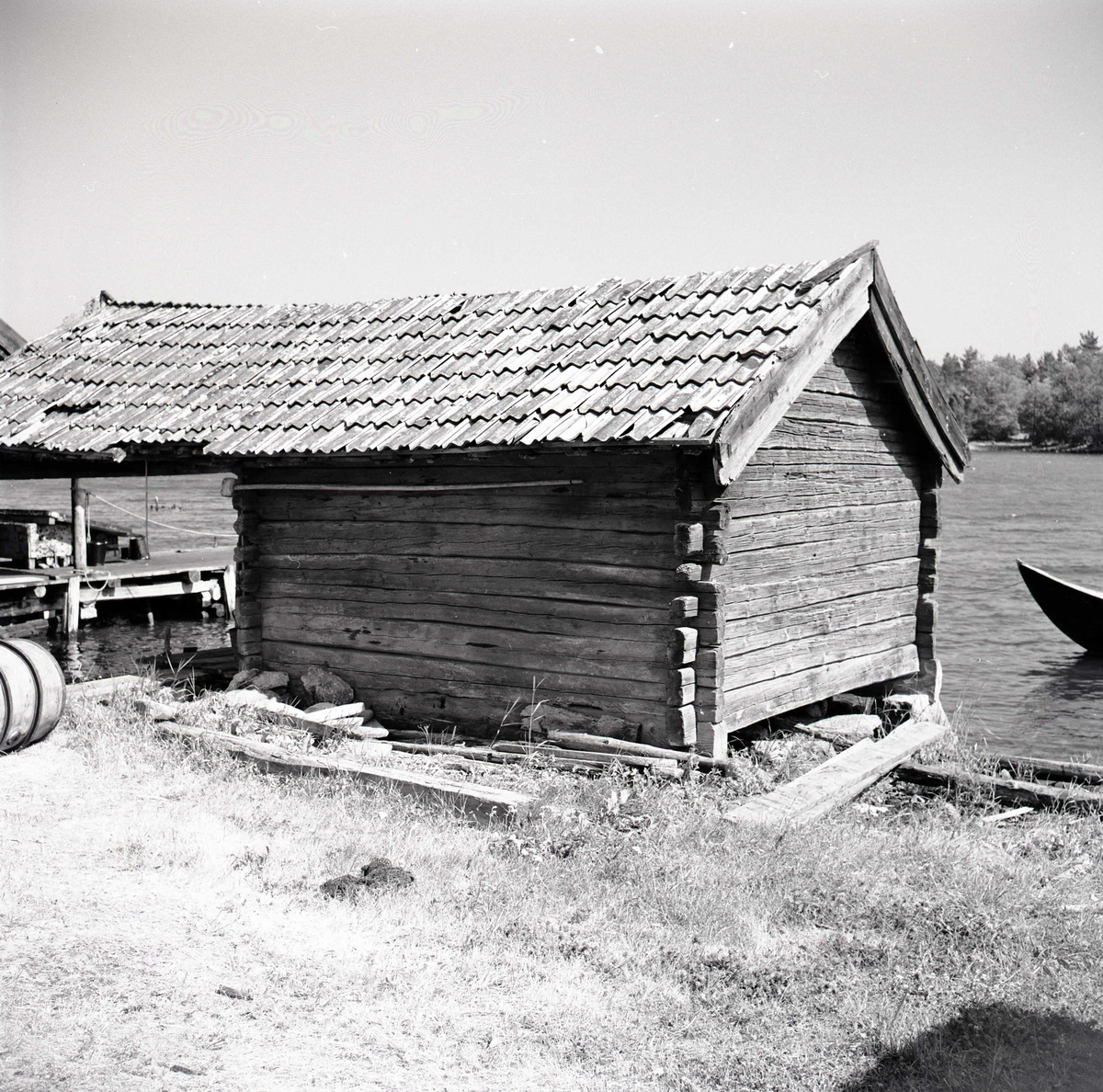 Sjöbod med timrad fasad och korsknut.