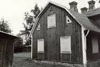 Tvåvånings bostadshus på Södra vägen i Kalmar. Huset verkar vara obebott och har förspikade fönster. Det skymtar en del av en takkupa till vänster i bild och till höger syns en del av ett uthus.