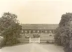 Ladugården sedd från mangårdsplanen. Röda skiftesverkslängor under bundet halmtak, från 1800-talets senare del.