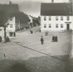 Stortorget fotograferat från apoteket Lejonet, före detta apoteket Kronan. På platsen för detta apotek står sedan 1964 Skandiahuset. Till höger i bild Svanholms hotell, Stadshotellets föregångare. Till vänster syns överbyggnaden på den allmänna vattenpumpen.