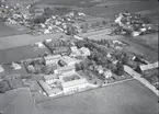 Flygfoto över Skogsby. Samhället med Folkhögskola byggnader och väg.