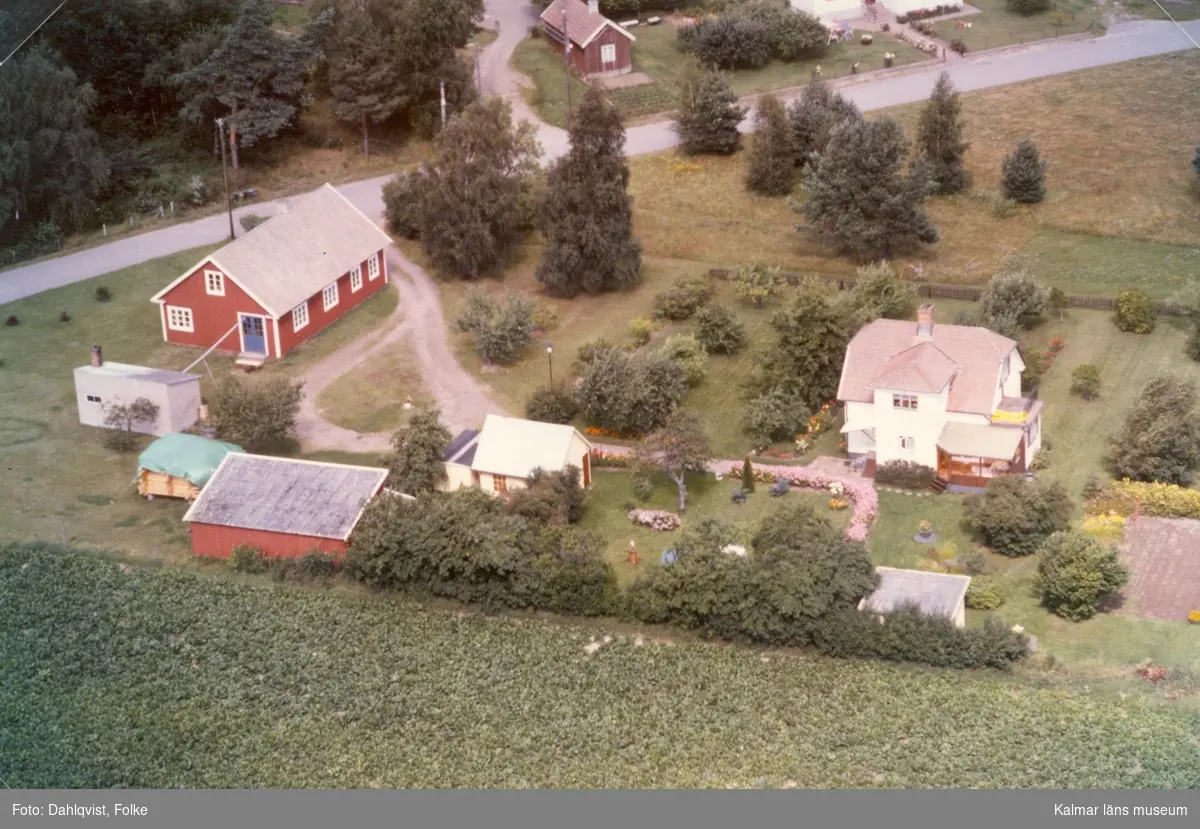 Bostadshus med sidobyggnader och trädgård i Arby socken.