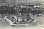 Flygbild med Kalmar slott och Gamla staden från öster. 

Bildens centrum är Kalmar slott från sjösidan. Norr om slottet syns en del av Stadsparken med de dåvarande växthusen. I bildens högerkant skymtar gamla stadsparksserveringen Byttan, vilken byggnad revs 1939. Bortom slottet, nästan rakt över Kuretornet, syns de Schuwertska växthusen i kvarteret Hasseln (Vegagatan/Frejagatan/Stensövägen).

Från slottets nordöstra postej går en 