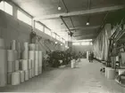 Kalmar Nya Tapetfabrik. Pårullning i en fabrikshall. Tapetrullar till vänster.