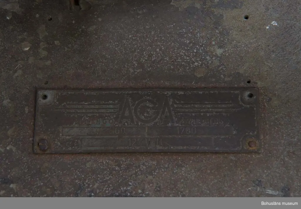 Skärbrännare för skärning av tjock stålplåt av fabrikat AGA. På ovansidan en plåt med ingjutna texten: 
AGA LIDINGÖ SWEDEN
KV - 560 / 1780 / 127 Volt
Reglage på ovansidan med rund skala med siffrorna 1 till 10.
Ställbart munstycke på ledbar arm med motvikt och som kan justeras med milimeterpassning enligt skala.
Vippkontakt med text: Till /Från
Märkt med tuschpenna: SÖRVIK
