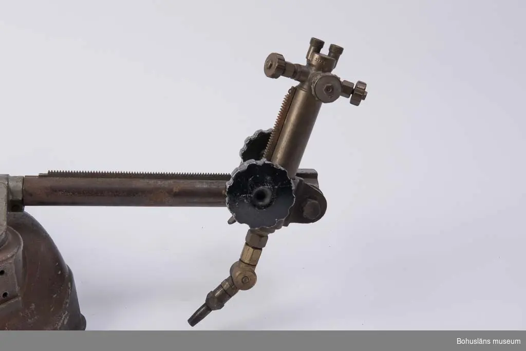 Skärbrännare för skärning av tjock stålplåt av fabrikat AGA. På ovansidan en plåt med ingjutna texten: 
AGA LIDINGÖ SWEDEN
KV - 560 / 1780 / 127 Volt
Reglage på ovansidan med rund skala med siffrorna 1 till 10.
Ställbart munstycke på ledbar arm med motvikt och som kan justeras med milimeterpassning enligt skala.
Vippkontakt med text: Till /Från
Märkt med tuschpenna: SÖRVIK