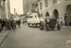 En parad under barnens dag. En traktor kör en vagn med folk i.