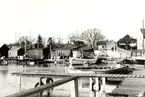 Stensö fiskeläge med båtbryggor, båtar och fiskestugor.