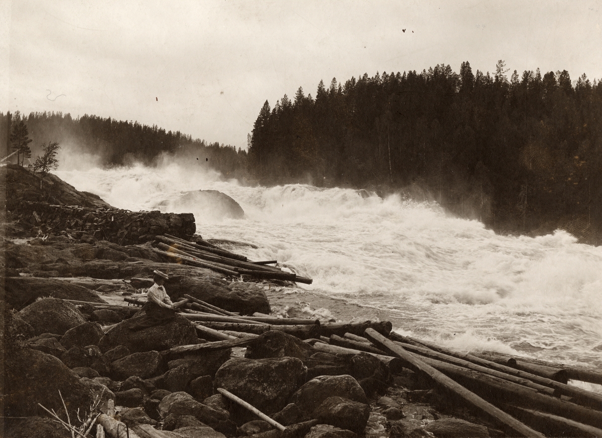 Kvinna på sten vid Fällforsen i Ume älv, juli 1908.