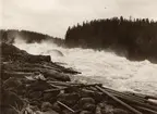 Kvinna på sten vid Fällforsen i Ume älv, juli 1908.