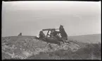 Tre militärer i gasmask bemannar kulspruta på klippa vid havet. Andra bilder i Bergers samling tyder på att detta fotografi tagits vid stridsövningen på Stabbo i Stockholms södra skärgård 1929, detta har dock inte kunnat bekräftas.