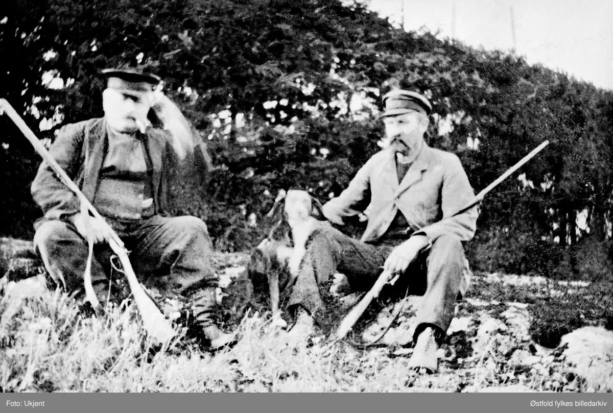 På jakt i Trøgstad ca. 1920. Jegerne er skomaker Nikolaisen og Hans Henningsmoen med hunden.