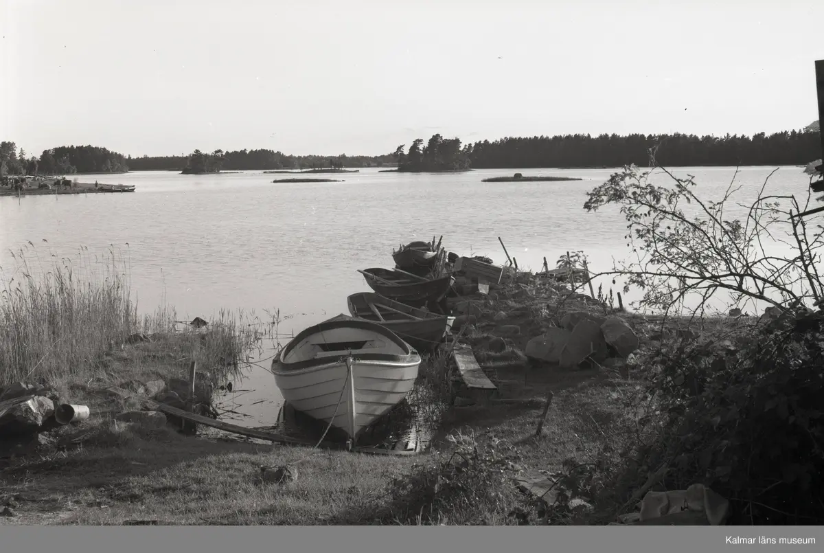 Vy med båtar och holme i bakgrunden.